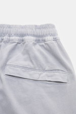 Close-up rear view of Stone Island Cargo Jogpants smoky blue showing elastic waistband and back pocket with snap button, made from soft, garment-dyed organic cotton with stretch for comfort and style.