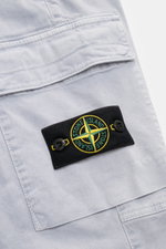 Close-up front view of Stone Island Cargo Jogpants smoky blue showing elastic organic cotton fabric, cargo pocket flap, and compass badge.