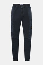 Front view of Stone Island Cargo Jogpants navy, made from elastic, piece-dyed organic cotton with stretch, featuring tapered fit, elastic waistband with drawstring, zip fly, concealed zipper and cargo pockets, darts at knee, back snap-button pocket, elast