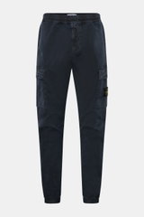 Front view of Stone Island Cargo Jogpants navy, made from elastic, piece-dyed organic cotton with stretch, featuring tapered fit, elastic waistband with drawstring, zip fly, concealed zipper and cargo pockets, darts at knee, back snap-button pocket, elast