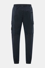 Rear view of Stone Island Cargo Jogpants navy, tapered fit cargo jogpants in garment dyed elastic organic cotton with concealed zip and cargo pockets, elastic cuffs, and compass badge.