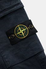 Close-up of Stone Island Cargo Jogpants navy showing the black compass badge with yellow and green embroidery on the side pocket, photographed from a side angle.

Description: For everyone who wants to combine function and style: These cargo jogpants by S