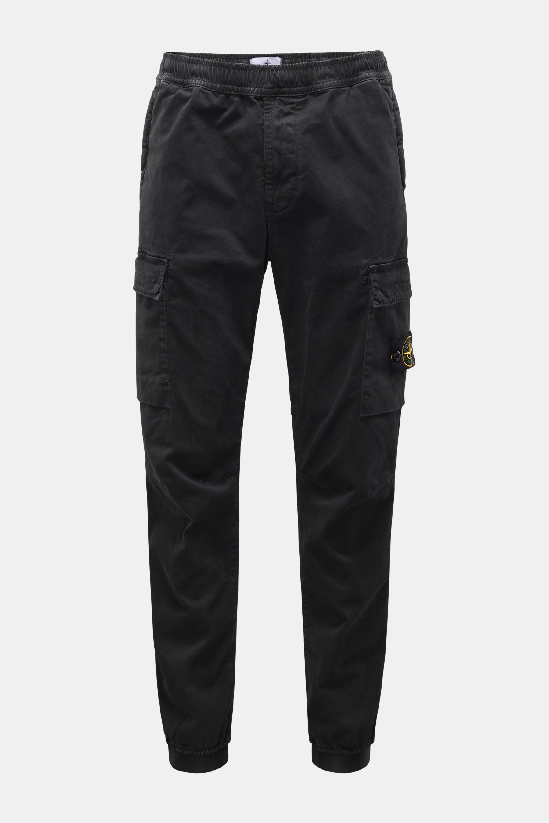 Front view of Stone Island Cargo Jogpants black, tapered fit with elastic waistband, drawstring, zip fly, cargo pockets, and compass badge, made from elastic organic cotton with soft touch, garment dyed, short cut, with concealed zipper pockets, darts at 