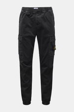 Front view of Stone Island Cargo Jogpants black, tapered fit with elastic waistband, drawstring, zip fly, cargo pockets, and compass badge, made from elastic organic cotton with soft touch, garment dyed, short cut, with concealed zipper pockets, darts at 