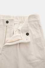 Frontansicht der geöffneten 04651/ A trip in a bag Cordhose offwhite mit Reißverschluss, Bundknopf, elastischer Baumwolle und feiner Cordstruktur.