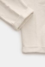 Detailaufnahme von der 04651/ A trip in a bag Cordhose offwhite mit weichem, elastischem Baumwoll-Cord, fixiertem Saumaufschlag und schmal zulaufendem Tapered Fit.
