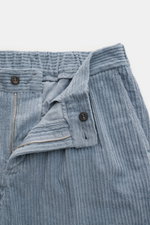 04651/ A trip in a bag Cordhose rauchblau, Detailaufnahme von Bund und Reißverschluss, elastische Baumwolle, weicher Griff, tapered Fit, knöchellang, schmal zulaufend.