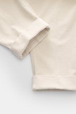 Close-up of Berwich Corduroy pants 'Chiaia' cream showcasing the soft, slightly elastic cotton corduroy fabric and fixed hem turn-up from a top-down perspective.