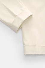 Berwich Chino 'Chiaia' creme, Detailaufnahme des fixierten Saumaufschlags und glatten Twill-Baumwollstoffs in Tapered Fit, knöchellang.