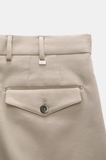 Nahaufnahme der rückwärtigen Bundpartie der PT Torino Baumwollhose 'Carrot Fit' beige, Twill aus reiner Baumwolle, mit Reißverschluss, Bundknöpfen, doppelter Bundfalte, französischen Taschen, Gesäßtaschen mit Patte und Knopf, fixiertem Saumaufschlag, weic