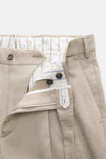 Nahaufnahme der geöffneten PT Torino Baumwollhose 'Carrot Fit' beige, Twill Baumwolle, weicher Griff, Reißverschluss, Bundknöpfe, kleine Uhrentasche.