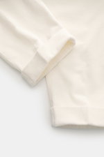 Close-up detail of PT Torino Corduroy Pants 'Carrot Fit' cream fabric and cuff, photographed from a top-down perspective, showcasing soft cotton corduroy texture and fine ribbing.