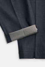 PT Torino Trousers 'The Rebel' grey blue melange shown from a close-up side angle, highlighting the stretch cotton and virgin wool twill fabric, soft touch, elastic waistband, tapered ankle length, and detailed cuff with button fly. Comfort meets style in