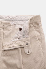 Brunello Cucinelli Beige Corduroy Pants shown from a top front angle, featuring zipper, buttons, soft pure cotton fabric, single pleat, French and welt pockets, regular fit with slim tapering. Corduroy workwear material garment dyed for a luxurious touch.