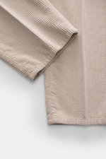 Brunello Cucinelli Beige Corduroy Pants shown from a close-up top-down view, highlighting soft cotton fabric, single pleat, and texture.