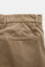 Brunello Cucinelli Light brown corduroy pants shown from the back close-up, featuring pure cotton fabric, soft feel, garment dyed, regular fit, very slim tapering, zipper and waistband buttons, French pockets, single pleat, and welt pockets. Corduroy can 