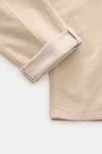 Incotex Corduroy Pants Beige shown from a close-up side angle, featuring cotton corduroy, slightly elastic quality, soft touch, regular fit, very tapered, zip fly, double waistband pleat, French pockets, and piped back pockets with button.