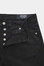 Jacquemus Jeans schwarz aus Denim reiner Baumwolle, Regular Fit, gerader Schnitt, Button Fly, Five-Pocket, innenliegendes Weblabel, Nahaufnahme von oben.