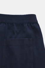 Jacquemus Denim-Jogpants dunkelblau, Detailaufnahme von hinten oben, Denim aus reiner Baumwolle, weicher Griff, Loose Fit, gerader Schnitt, elastischer Bund, aufgesetzte Gesäßtaschen, innenliegendes Weblabel, Button Fly.