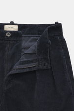 The Row Cordhose 'Tuxo Pant' navy aus samtigem Baumwoll-Cord, knöchellang mit Reißverschluss, Bundknopf und doppelter Bundfalte, Detailfoto von oben.