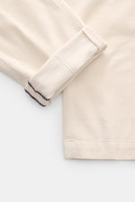 Close-up top view of Mason's Corduroy Pants 'Torino Style' offwhite showing soft, slightly elastic cotton and lyocell fabric with visible ribbed texture and rolled cuff with neat stitching, highlighting slim fit, tapered design, garment dyed finish, zip f