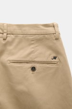 Close-up rear view of Mason's Chino 'Torinostyle' beige pants showing piped back pockets with button, typical metal initial, slim tapered fit, soft touch fabric made of modal, cotton, and microfiber, zipper and waistband buttons, and French pockets.