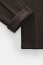 Nahaufnahme der dunkelbraunen Dondup Chino 'Gaubert' mit umgeschlagenem Bein, zeigt elastische Baumwoll-Lyocell-Mischung, Slim Fit, schmale Wade, Reißverschluss, Slide Button, französische Taschen, Gesäßtaschen mit Knopf und typisches Metall-Initial.