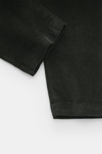 Nahaufnahme aus seitlicher Perspektive der Dondup Cordhose 'Ben' dunkelgrün mit Cord aus reiner Baumwolle, leicht elastisch, weicher Griff, Tapered Fit, knöchellang, Bundfalte, französischen Taschen, Gesäßtaschen mit Knopf und Metall-Initial.