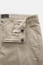 Nahaufnahme der geöffneten Dondup Chino 'Gaubert' beige aus elastischer Baumwolle, Slim Fit mit schmal geschnittener Wade, Reißverschluss und Slide Button, französischen Taschen, Gesäßtaschen mit Knopf und typischem Metall-Initial, frontal fotografiert.