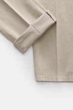 Nahaufnahme der Dondup Chino 'Gaubert' beige, fotografiert von oben, zeigt den umgeschlagenen Beinabschluss, elastische Baumwolle, Slim Fit, schmal geschnittene Wade, Reißverschluss und Slide Button, französische Taschen, Gesäßtaschen mit Knopf und typisc