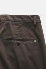 Nahaufnahme der Dondup Chino 'Gaubert' dunkelbraun, Rückansicht mit französischen Taschen, elastischer Baumwolle, Slim Fit, schmaler Wade, Reißverschluss, Slide Button, Gesäßtaschen mit Knopf und metallischem Initial.