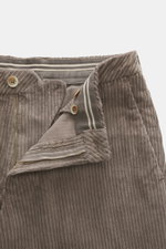 Close-up front view of GTA Corduroy Pants 'Davide' taupe showing zipper, waistband button, internal elastic band, made of cotton corduroy with elastic quality, smooth touch, regular fit, slightly tapered, French pockets, small logo detail, and back pocket