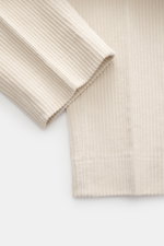 Close-up image of the fabric texture of GTA Corduroy Pants 'Davide' sand, showing cotton corduroy material with stretch quality and smooth touch, photographed from a top-down perspective. Features regular fit, slightly tapered legs, zipper and waistband b