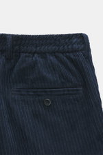 Close-up front view of navy GTA Corduroy Pants 'Davide' showing cotton corduroy fabric, elastic quality, smooth touch, regular fit, slightly tapered, zipper and waistband button, internal elastic band, French pockets, small logo detail, and back pockets w