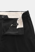 GTA Jersey-Hose 'Dennis' schwarz aus elastischem Jersey mit Reißverschluss, Bundknopf, innenliegendem Band, französischen Taschen, schmal zulaufend, Detailansicht.