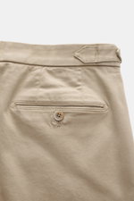 GTA Chino 'Herrick' beige shown from the back, featuring elastic cotton, soft touch, regular fit, low rise, zipper and waistband button, elastic insert in waistband, side adjuster, double waistband pleat, French pockets, and back pockets with button.