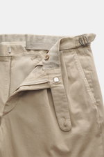 GTA Chino 'Herrick' beige shown from the front close-up, featuring elastic cotton, soft touch, regular fit, low rise, zipper and waistband button, elastic insert, side adjuster, double waistband pleat, French pockets, and back pockets with button.