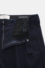 Geschlossenes Nahaufnahmefoto der geöffneten Closed Baumwollhose 'Bergen Tapered' navy mit Reißverschluss, Bundhaken, Twill-Struktur, weichem Griff, Tapered Fit, französischen Taschen, Bundfalte und Metall-Initial.
