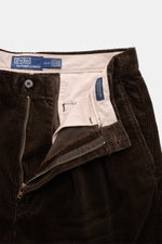 Polo Ralph Lauren Cordhose 'Whitman' dunkelbraun, Cord aus Baumwolle, kurzer Schnitt, Bundfalten, Reißverschluss, Knopf, Detailansicht von oben.
