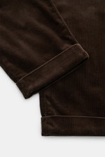Nahaufnahme der Polo Ralph Lauren Cordhose 'Whitman' dunkelbraun, fotografiert von oben, zeigt die weiche Baumwollstruktur und fixierten Saumaufschlag.