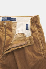 Nahaufnahme der geöffneten Polo Ralph Lauren Cordhose 'Whitman' camel mit Reißverschluss, Bundknopf, Bundfalten und weichem Baumwollcord, frontale Perspektive.