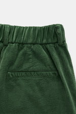 Close-up front view of green corduroy waistband and back pocket of 04651/ A trip in a bag Corduroy Pants Cream, featuring soft cotton corduroy, slim fit, ankle length, seersucker inner side, zipper and button, elastic waistband, French pockets, double ple