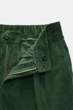 Green corduroy pants close-up from front top angle showing waistband, zipper, button, and partially elastic interior of 04651/ A trip in a bag Corduroy Pants Cream.