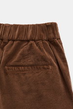 Close-up front view of the waistband and pocket area of 04651/ A trip in a bag Corduroy Pants navy, made of soft cotton corduroy with a seersucker inner side for comfort, featuring a slim fit, ankle length, slightly tapered leg, zipper and button closure,