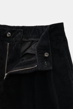 Close-up front view of 04651/ A trip in a bag Black Corduroy Pants showing cotton corduroy fabric, zipper, button, and waistband details.