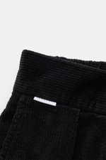 Close-up front view of the waistband and upper part of 04651/ A trip in a bag Black Corduroy Pants, made of soft cotton corduroy with a seersucker inner side, slim fit, ankle length, slightly tapered, featuring zipper, waistband button, partially elastic 