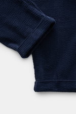 Close-up front view of navy blue 04651/ A trip in a bag Corduroy pants made of wide soft cotton corduroy with seersucker inside, showing the fixed hem cuff and textured fabric.