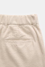 Close-up rear view of 04651/ A trip in a bag Corduroy pants sand, made of soft wide cotton corduroy with seersucker inside, regular fit, tapered, with waistband button, zipper, side seam pockets, double waistband pleat, welt back pockets, and fixed hem cu