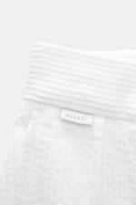 Close-up top view of 04651/ A trip in a bag Corduroy pants white showing soft cotton corduroy fabric and label.  
<p>These corduroy pants by 04651/ A TRIP IN A BAG are made of wide cotton corduroy with a seersucker backing, providing special wearing comfo