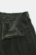 Close-up front view of 04651/ A trip in a bag Corduroy pants dark green showing soft wide cotton corduroy, zipper, button, and seersucker inside.